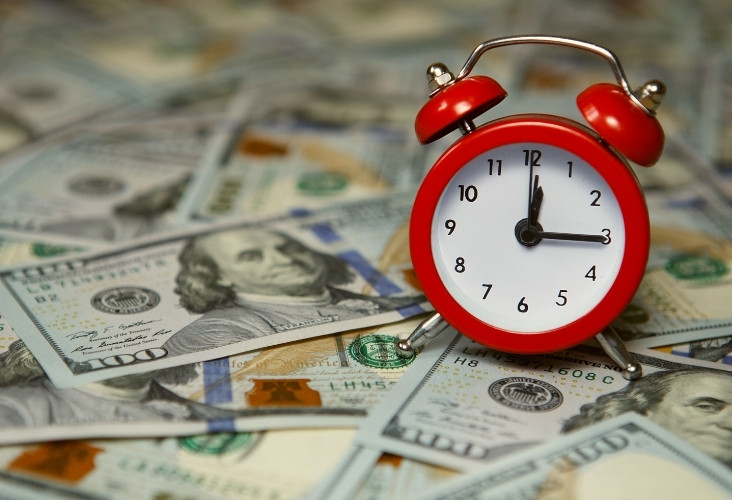 a clock with dollars below depicting hourly rate